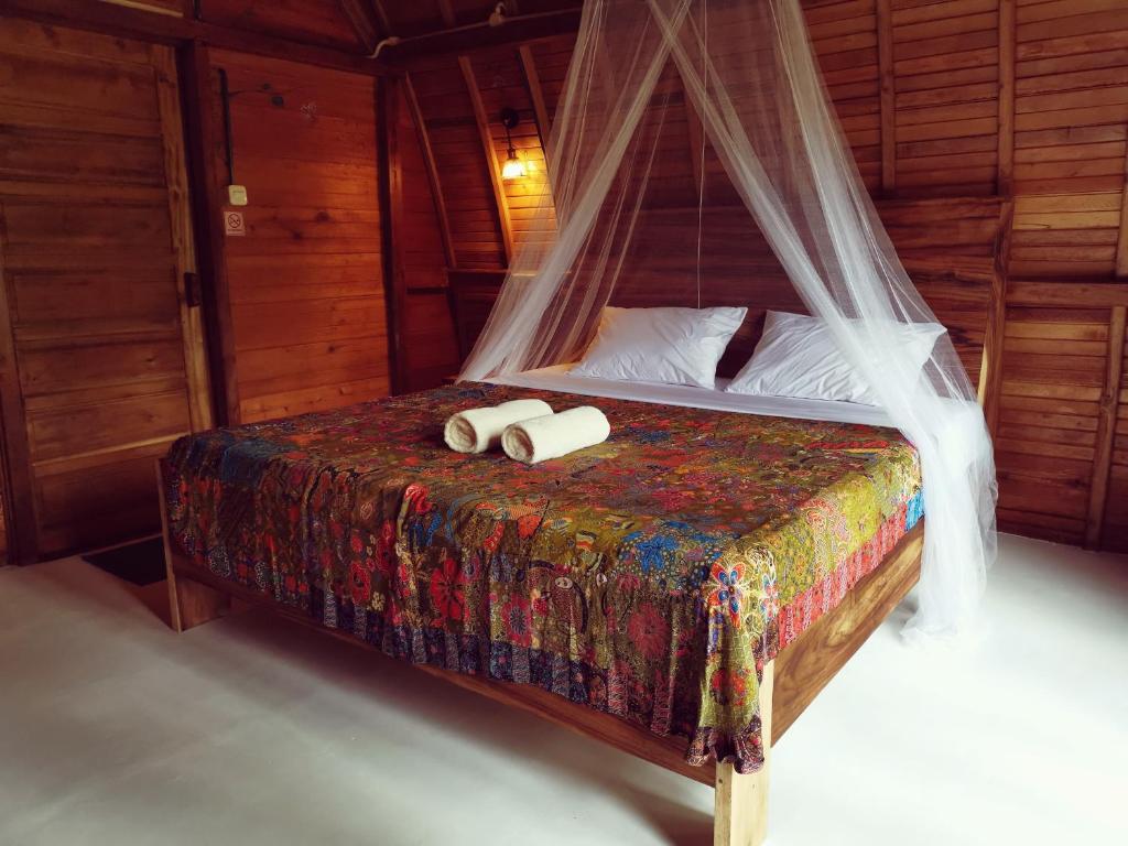 巴图卡拉Coconut Tree Cottages的一间卧室配有一张床,上面有两条毛巾