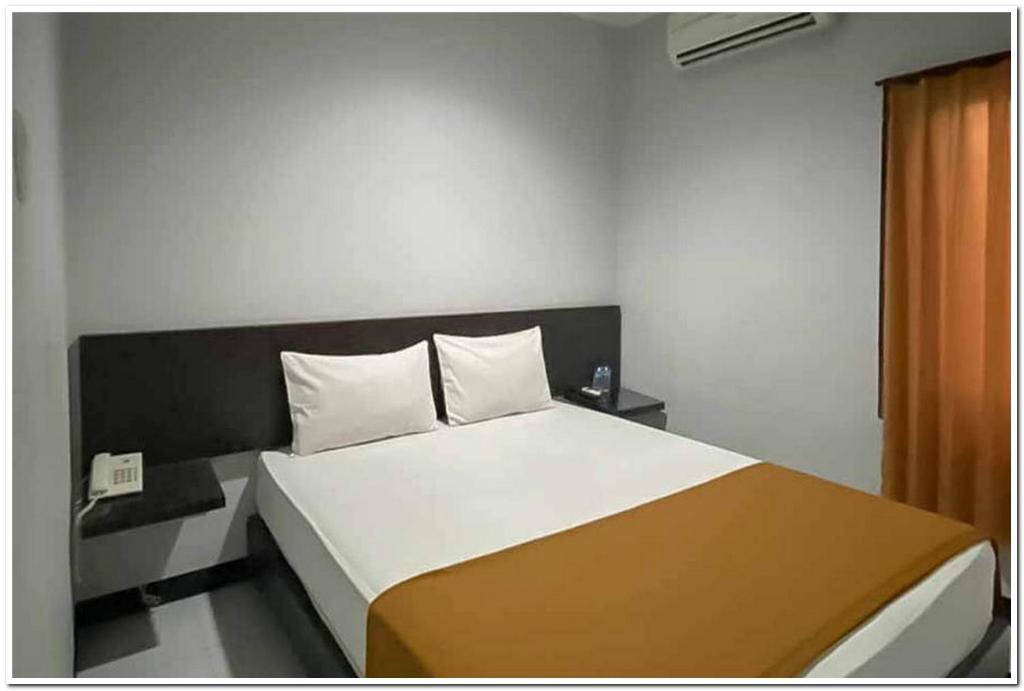 GabungLosmen Family Syariah Bypass Juanda Mitra RedDoorz的一间卧室配有一张大床,配有黑白床头板