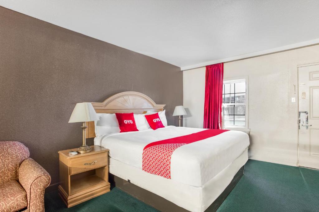 Bald KnobOYO Hotel Bald Knob near Searcy AR的一间卧室配有一张带红色枕头的大床