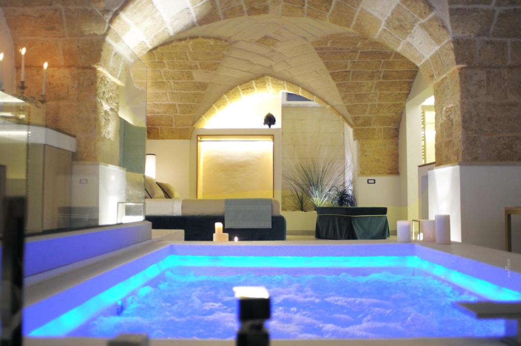 MiggianoLa Dimora delle Fate Luxury & SPA的一个带拱门的房间的大型游泳池