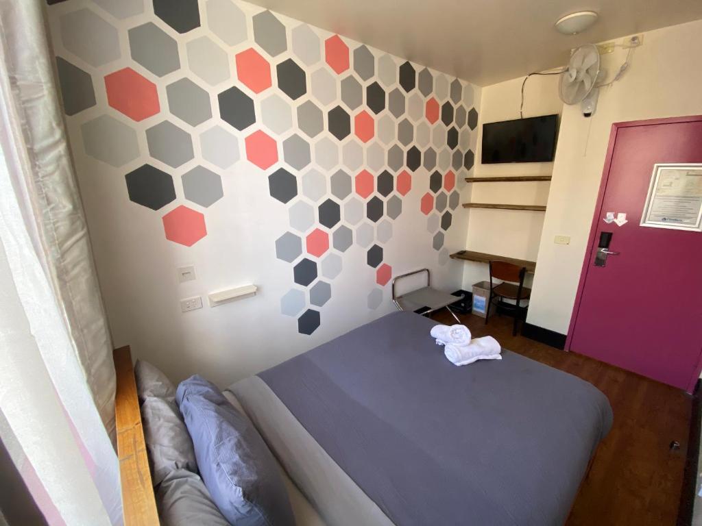 墨尔本Flinders Backpackers的一间卧室配有一张床和一堵六角形墙