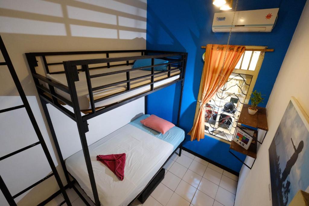 日惹维亚维亚宾馆的小房间设有双层床和窗户