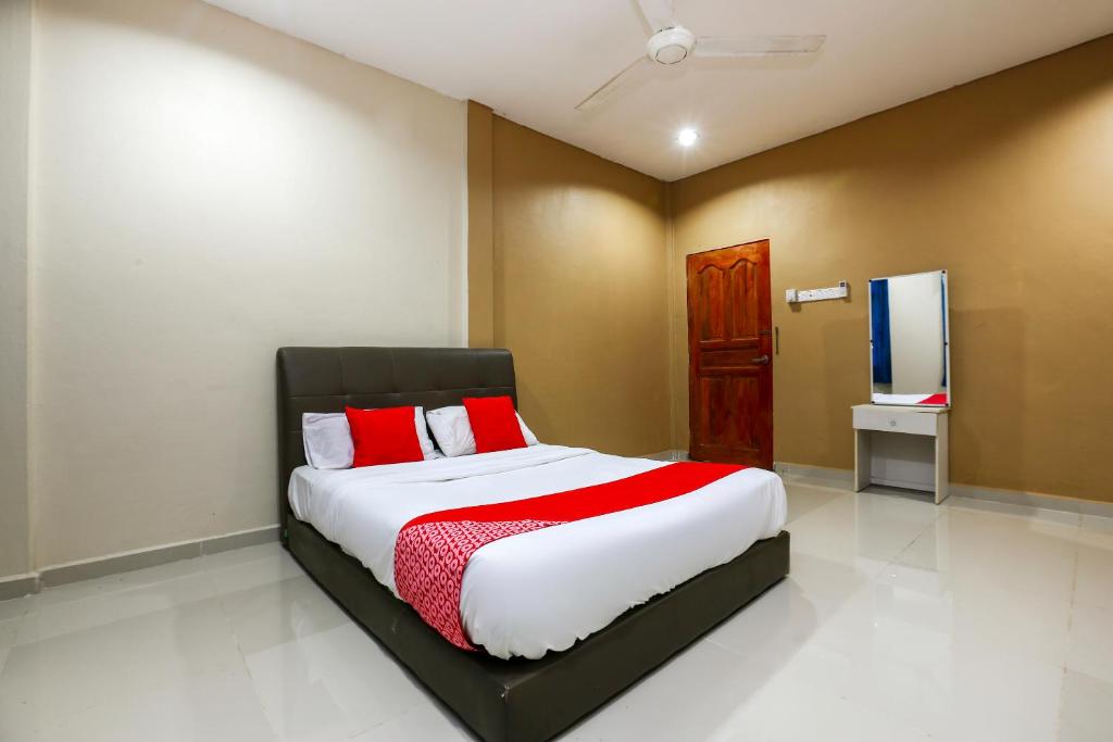 JeliOYO 89933 Nun Hotel的一间卧室配有一张带红色和白色床单的大床