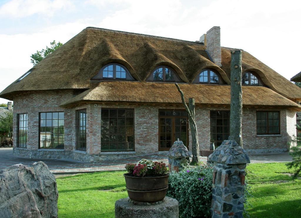 BubiaiMeškių dvarkiemis的一座带茅草屋顶的大型石屋
