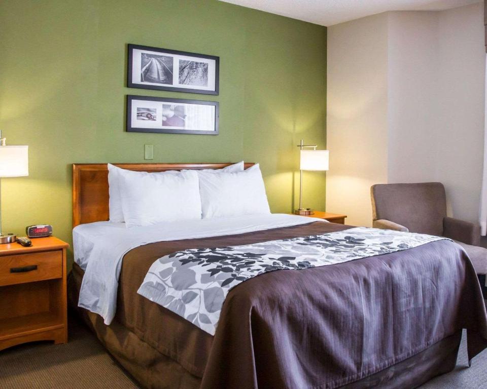 芝加哥安睡中途岛机场贝德福德公园酒店的配有一张床和一把椅子的酒店客房