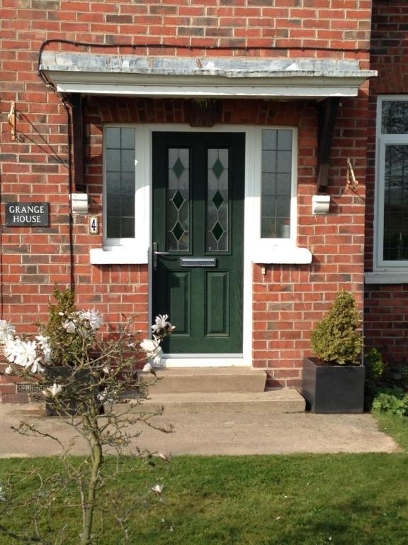 LowdhamGrange House Bed & Breakfast的砖房的绿色前门
