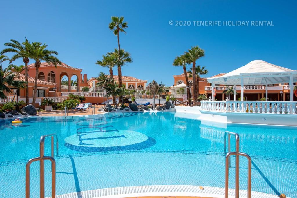美洲海滩Tenerife Royal Gardens - Viviendas Vacacionales的棕榈树度假村的大型游泳池