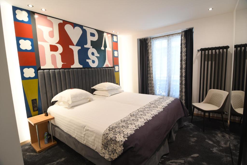 巴黎阿伊达歌剧酒店的卧室配有一张墙上大标志的床