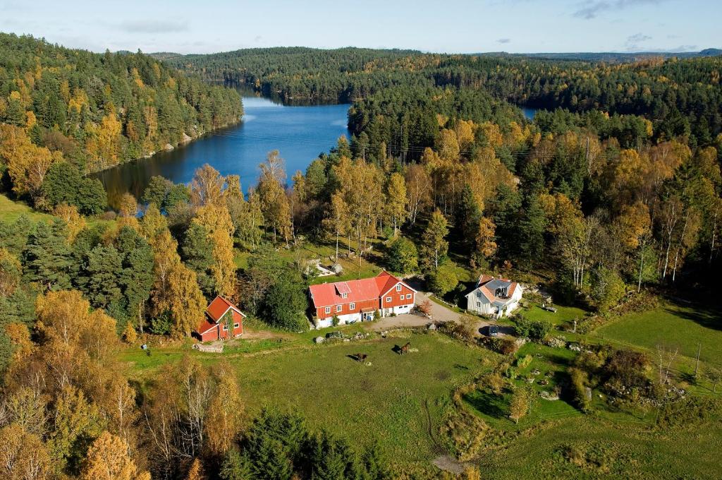 GällingeFinas Torpgård B&K的享有湖畔山丘上房屋的空中景致