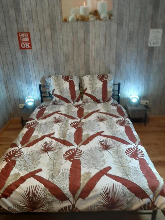 沙勒罗瓦ESCALE DU BOURLINGUEUR的床上有红白毯子