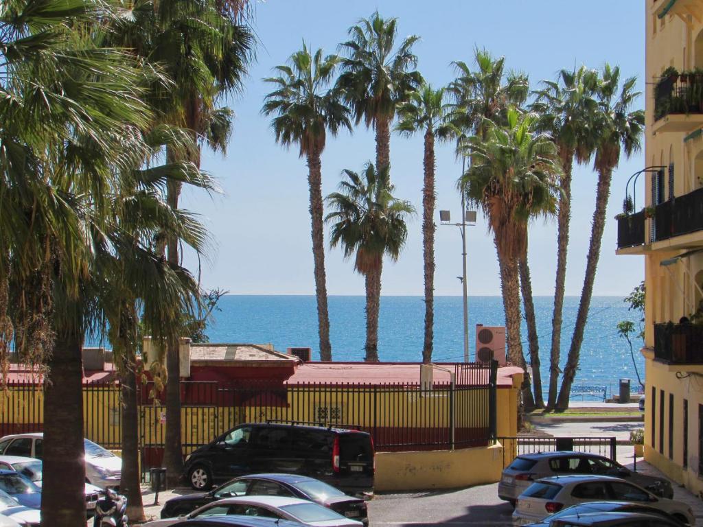 马拉加Apartamento a 50 metros de la playa malagueta con vistas al mar的棕榈树和海洋的停车场