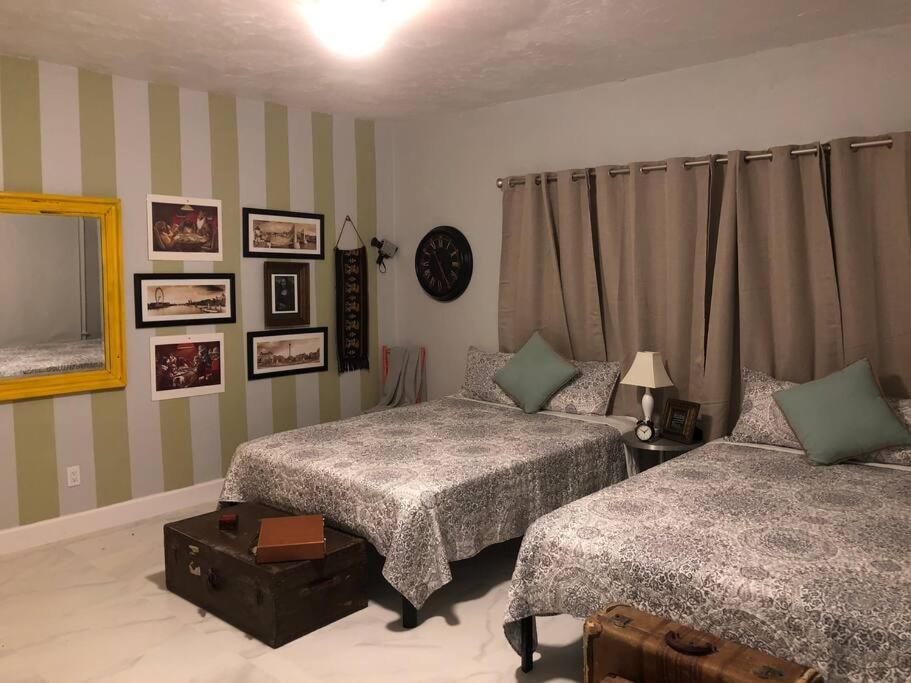 迈阿密Spacious and Comfy Suite near MIA - 6G的一间卧室配有两张床和镜子