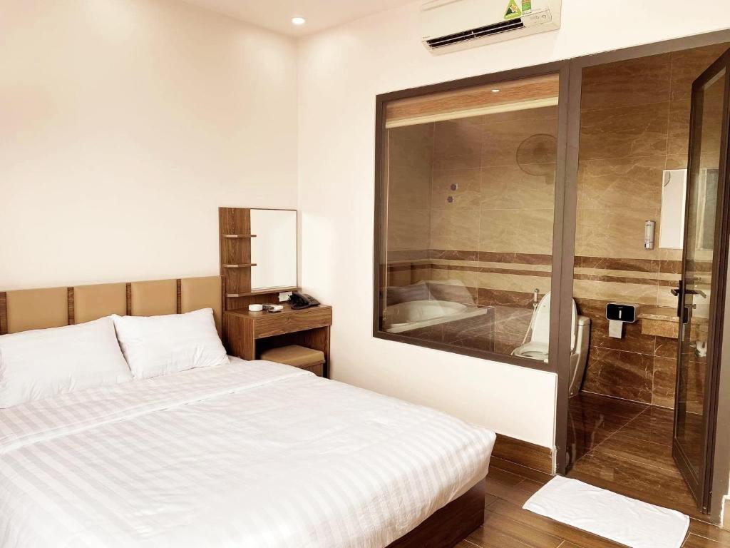 海防MV Hotel的一间卧室设有一张床和一个玻璃淋浴间