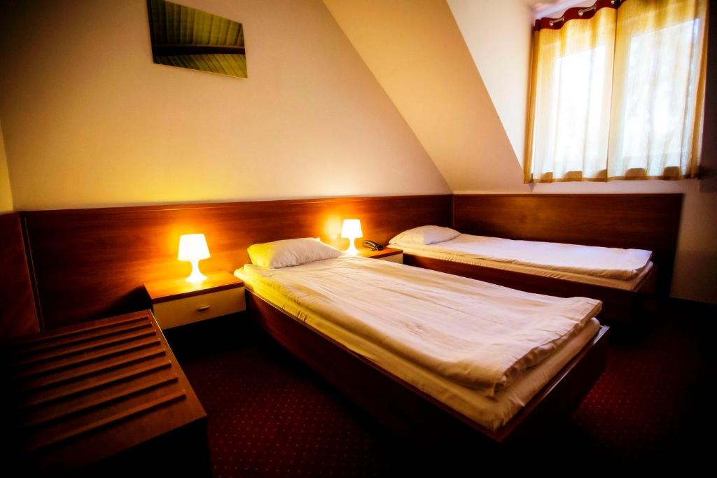 拉多姆Hotel LUKA的酒店客房设有两张床和两盏灯。