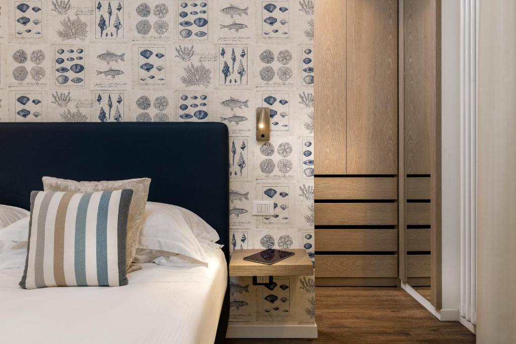 里乔内Residence Lungomare - Charming apartments的一间卧室配有一张蓝色和白色壁纸的床