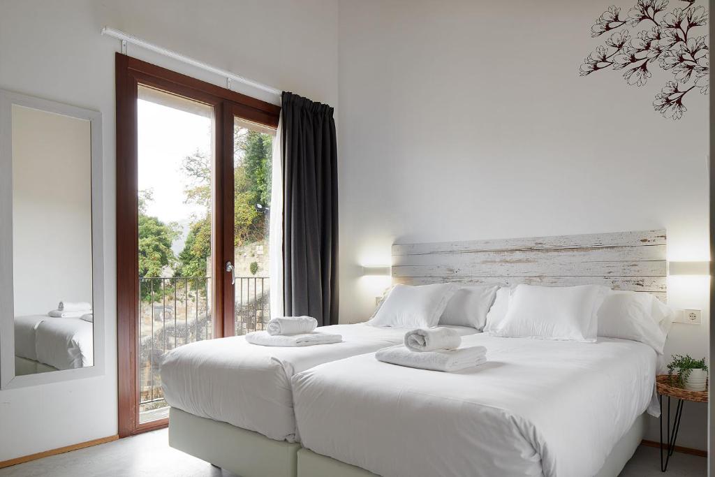 艾丝黛拉IRAIPE Estella Rooms的白色的卧室设有一张白色大床和一个窗户。