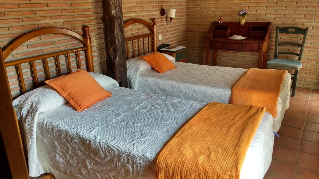 比略斯拉达德卡梅罗斯Casa rural La Media Legua的一间卧室配有两张床、一张桌子和一张书桌