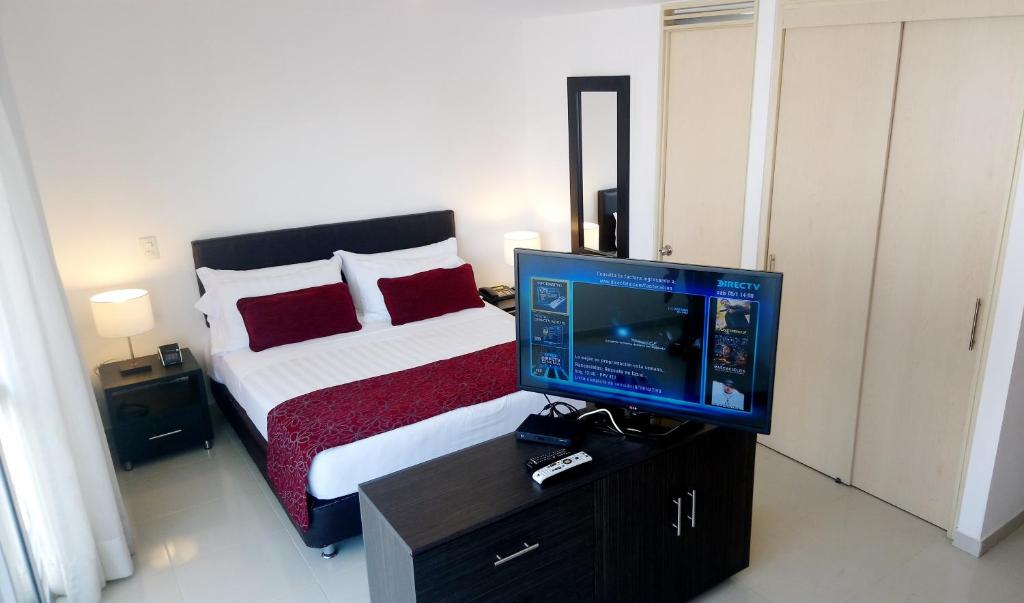 布卡拉曼加AMOBLADOS MCCORMICK的一间卧室配有一张床和一张桌子上的电视