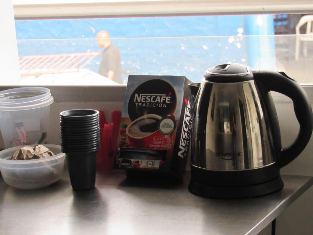 麦德林Hotel Murano Medellín的厨房柜台配有咖啡机和水壶