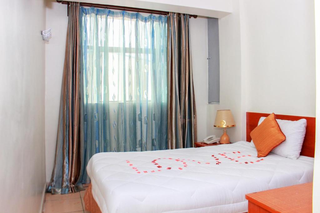 内罗毕Sheratton Regency Hotel Nairobi的一间卧室设有一张床和一个大窗户