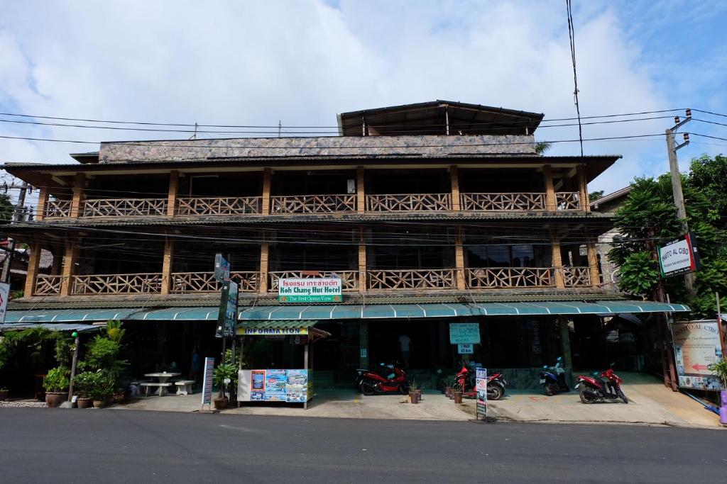 象岛象岛小屋酒店的一座大型木制建筑,前面停放着摩托车