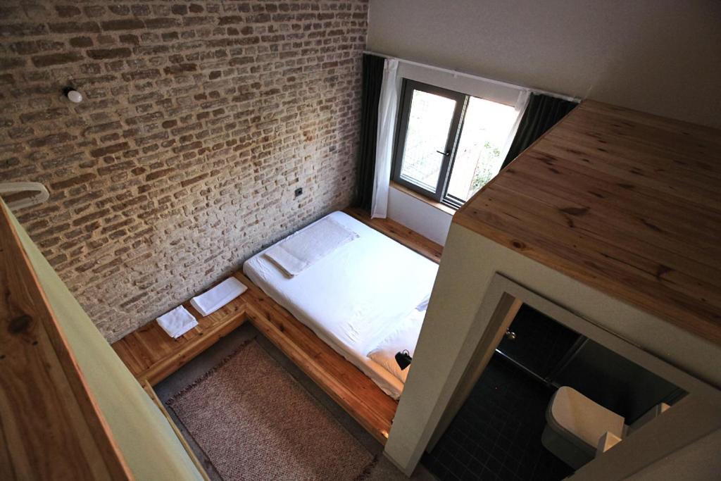安塔利亚FLANEUR HOSTEL的小房间,砖墙里设有一张床铺