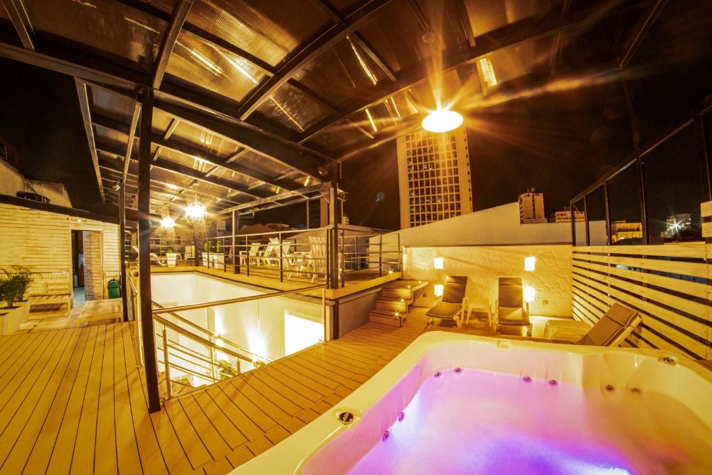 卡塔赫纳Casa Amanzi Hotel Cartagena的一座在甲板上设有热水浴缸的建筑
