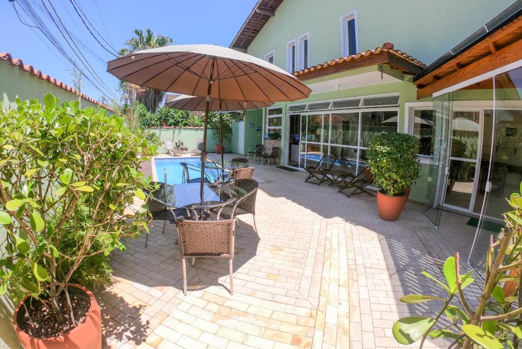 朱奎Pousada Etoile的一个带遮阳伞和椅子的庭院和一个游泳池