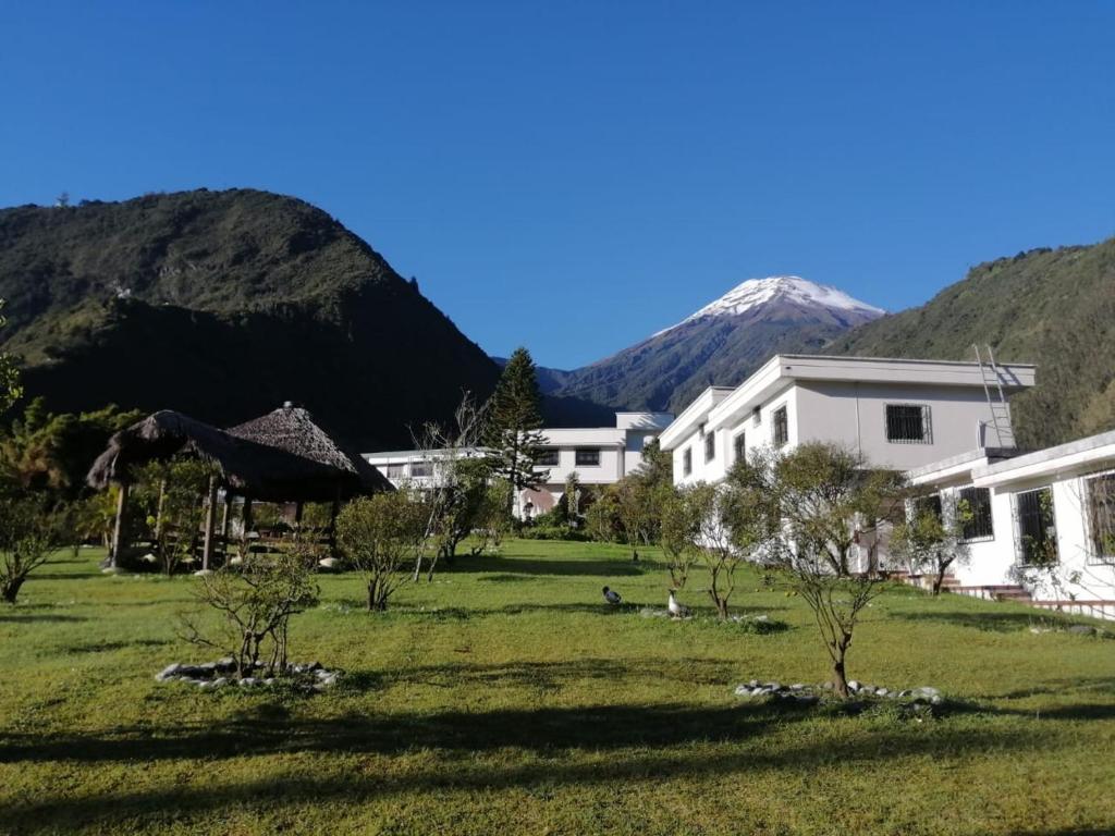 巴尼奥斯Casa del Peregrino Santo Thomas的一座白色的建筑,背景是群山