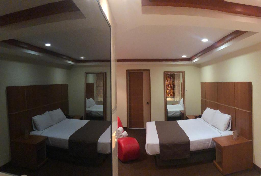 墨西哥城HOTEL ORION的酒店客房,设有两张床和镜子