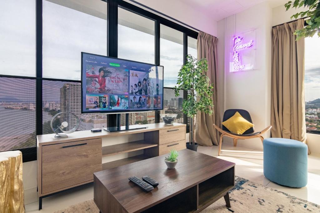 乔治市森瑞格尼公寓的一间带电视和大窗户的客厅