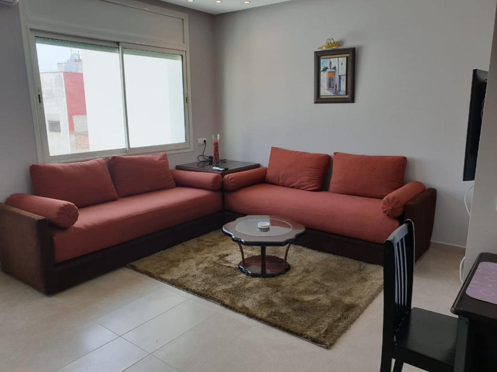 拉巴特Residence Davos Rabat的客厅配有红色的沙发和桌子