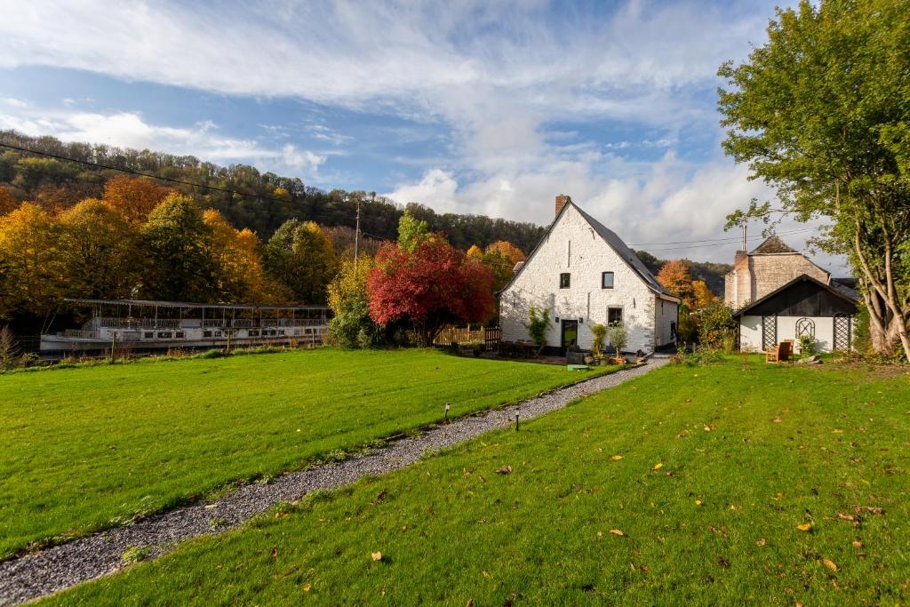 迪南Riverside Cottage Dinant的一座农场,有白色的房子和绿色的田野