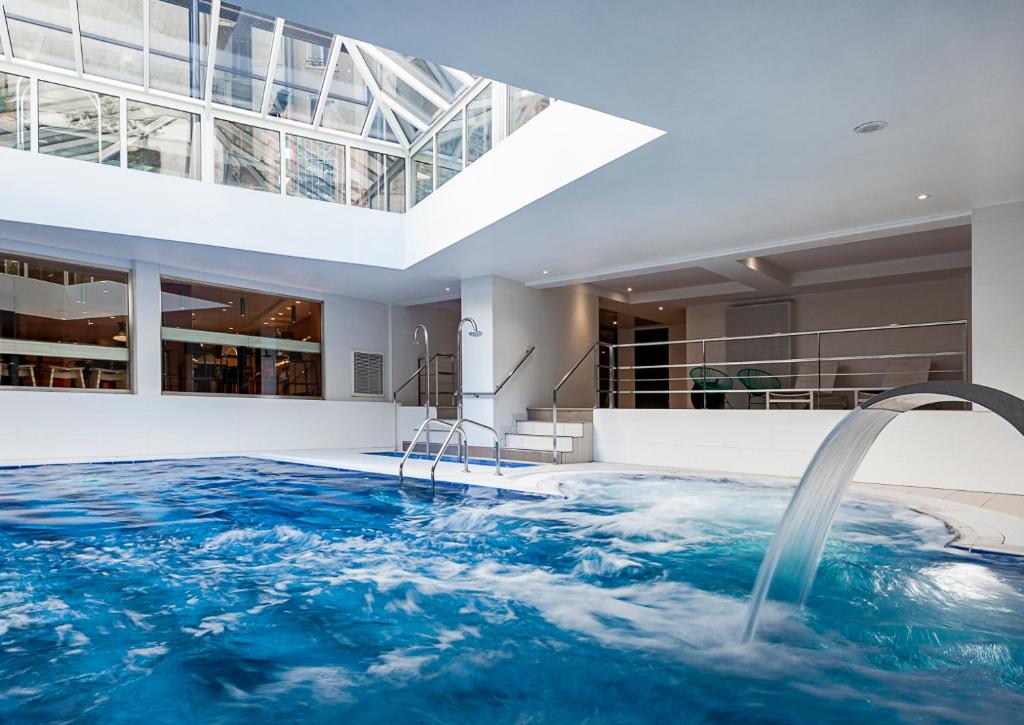 巴黎大洋洲巴黎凡尔赛门酒店的房屋内带水景的游泳池