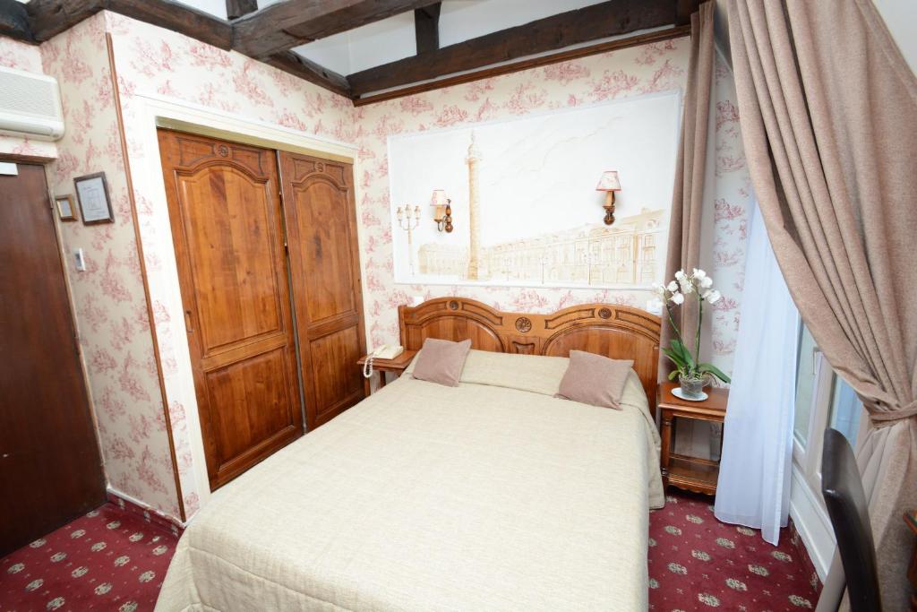 巴黎福美来酒店的一间小卧室,配有床和窗户