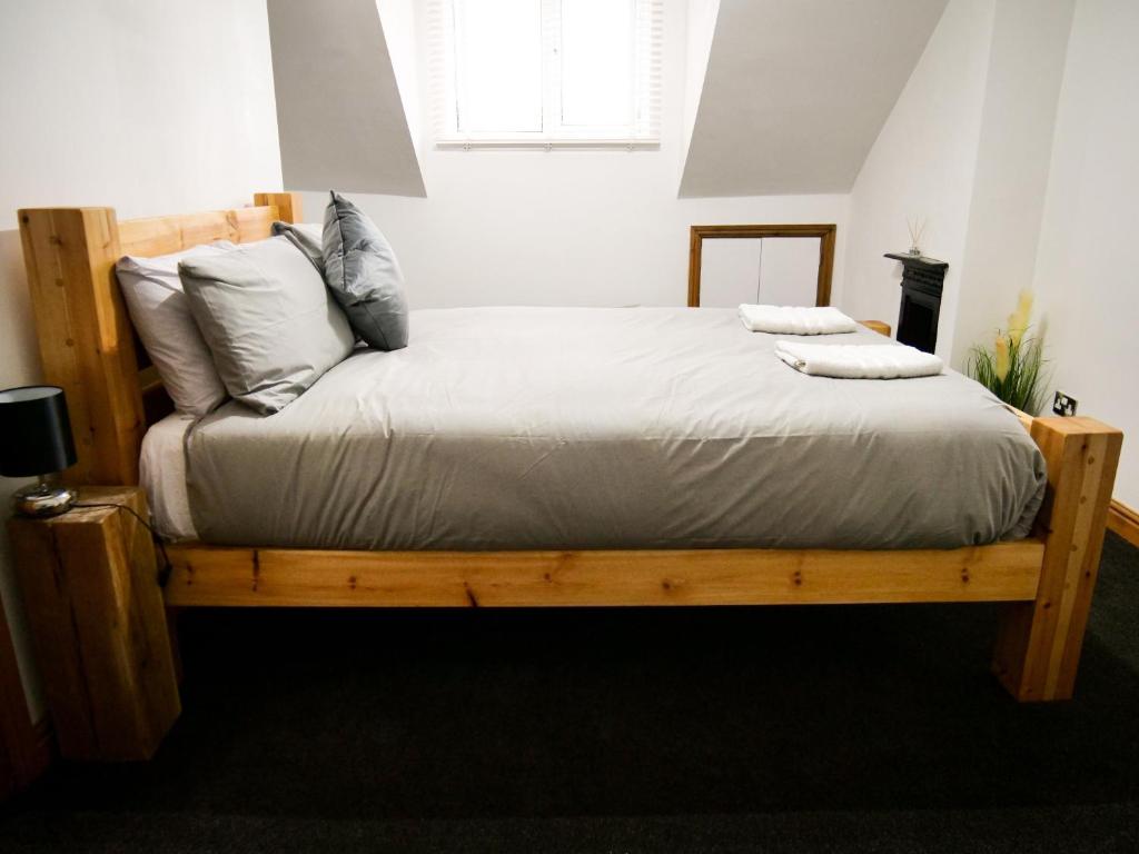 诺丁汉The Stone House的一间卧室配有一张带白色床单和枕头的木制床。