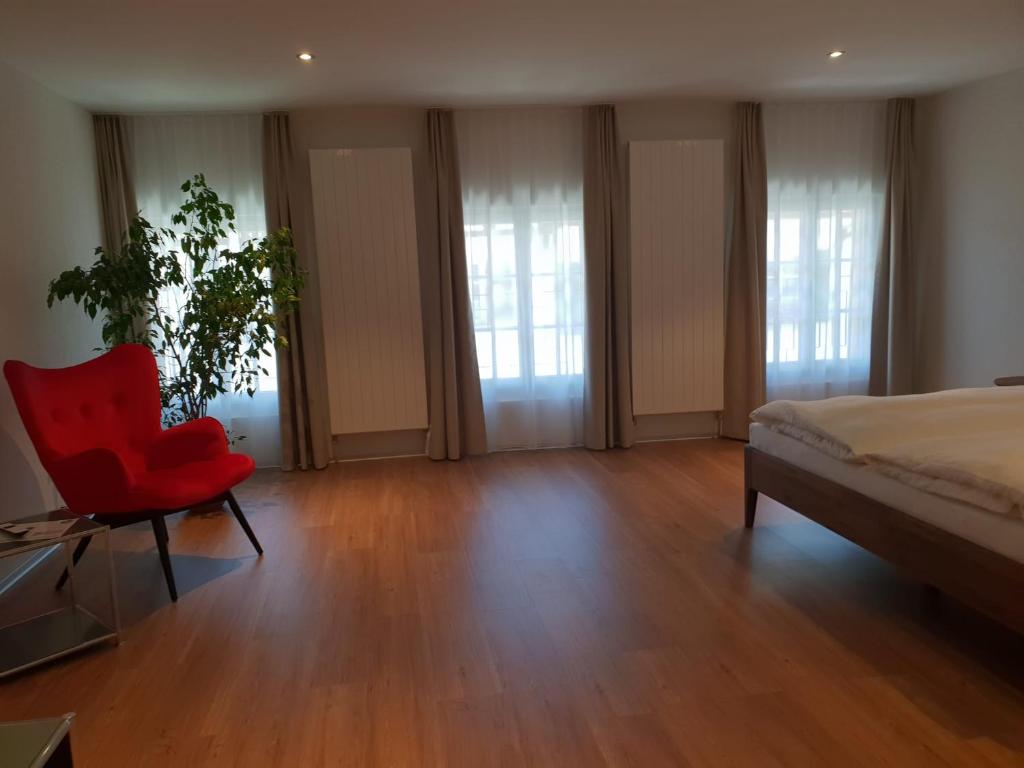 穆尔滕林姆尔酒店的一间卧室配有红色椅子和一张床