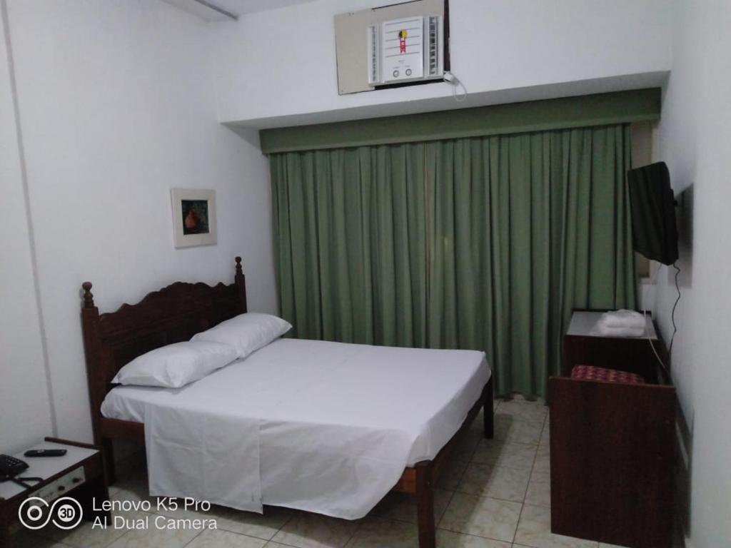 里约热内卢大西洋大道酒店的一间卧室配有床和绿帘