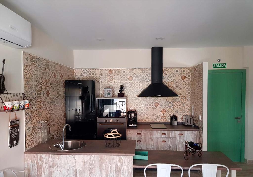 埃尔托尔诺Apartamentos La Chaparrina del Jerte的厨房配有黑色冰箱和绿门。