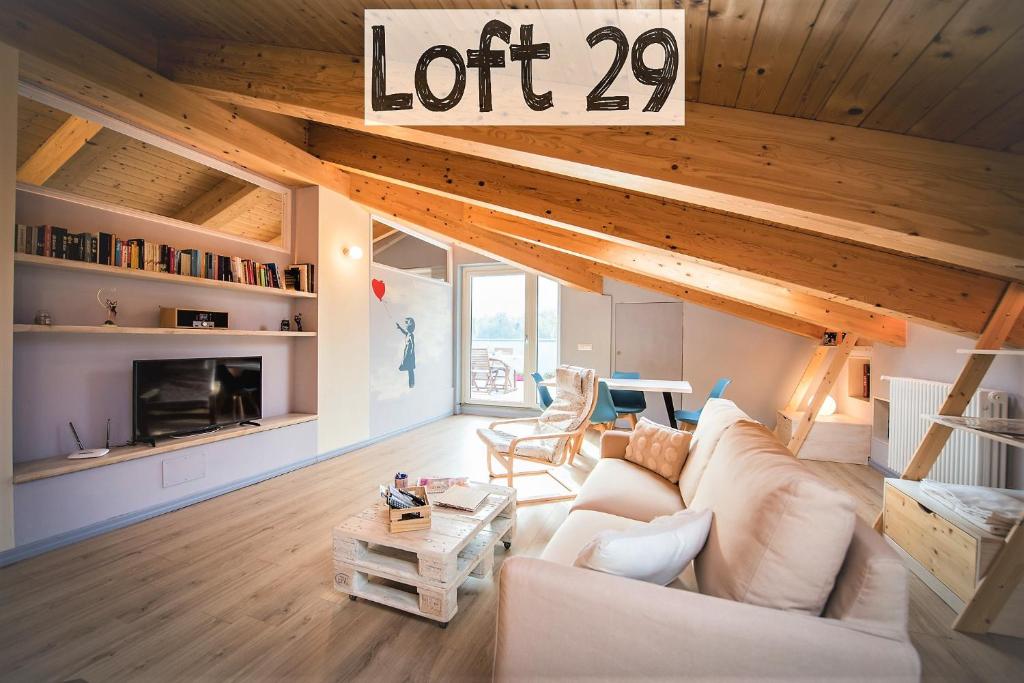 BussolenoLoft 29 mansardato con ampio terrazzo的客厅配有白色的沙发,有很多标志