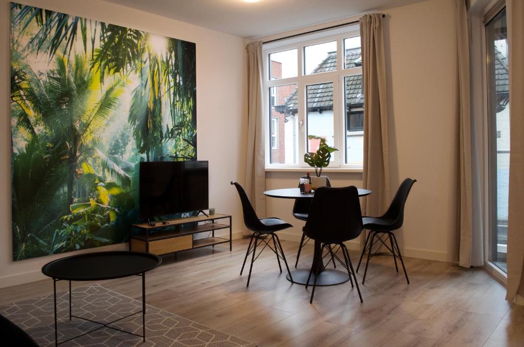 恩斯赫德The Residence Enschede的客厅配有桌椅和绘画作品