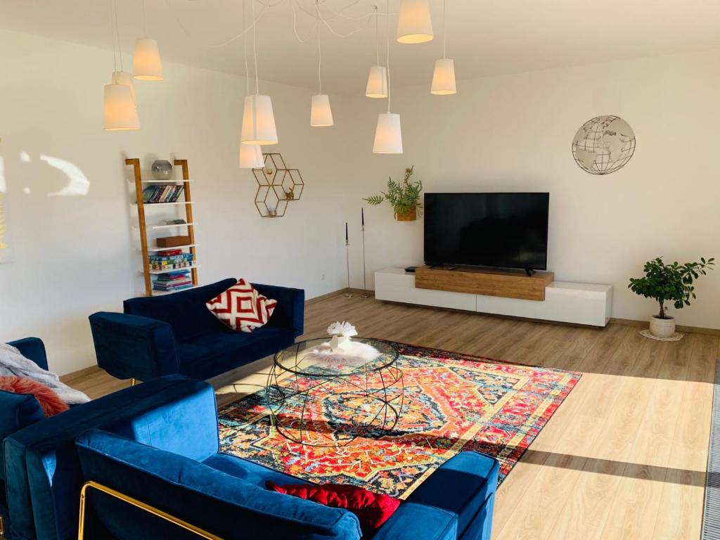 普福尔茨海姆Apartment Am Kupferhammer的客厅配有2张蓝色沙发和1台平面电视