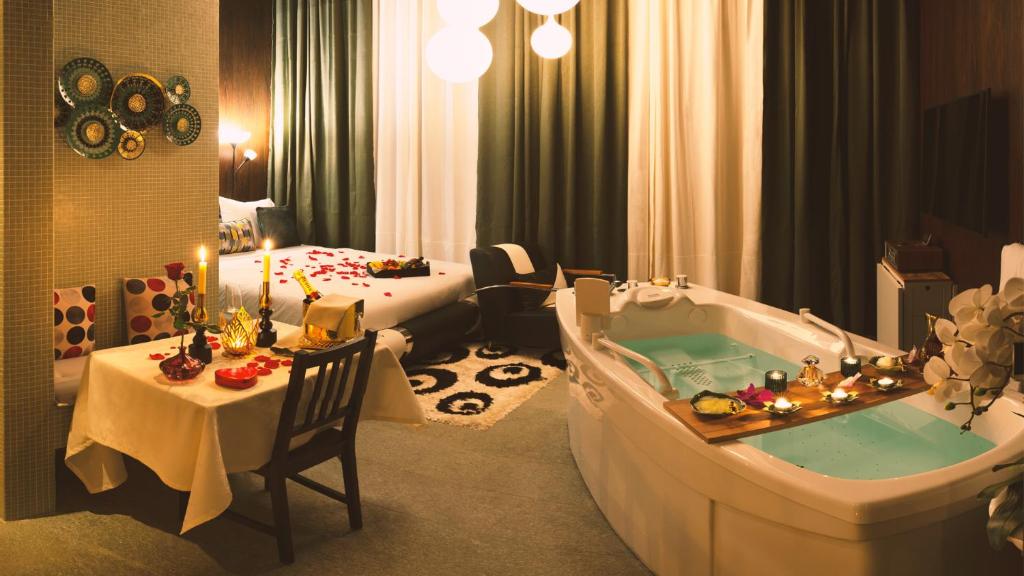 克洛滕Vitality Relax Spa Suite的带浴缸的酒店客房和一间卧室