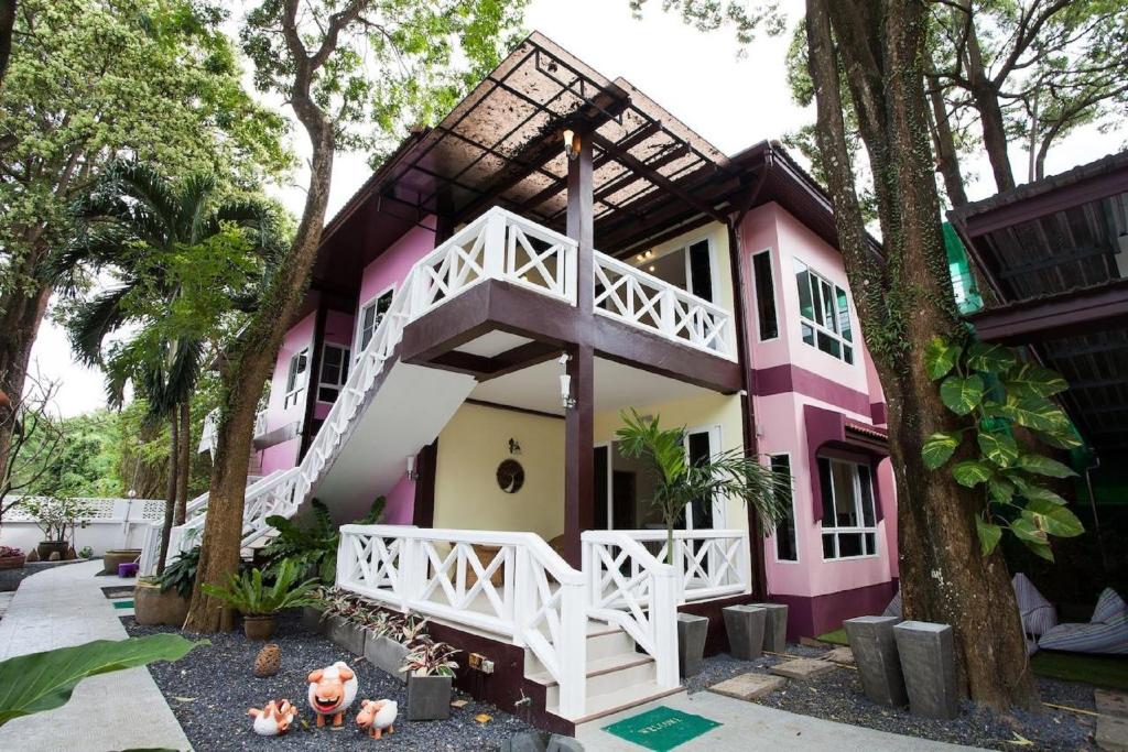 拉威海滩拉威桑迪之家酒店的粉红色和白色的房子,有树