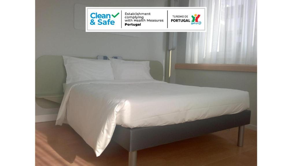布拉加布拉加中心宜必思快捷酒店的一张带白色床单和枕头的床