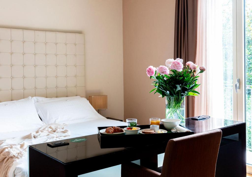 龙格甜蜜酒店的一间酒店客房,配有一张床铺和一张桌子,并提供一个食品托盘