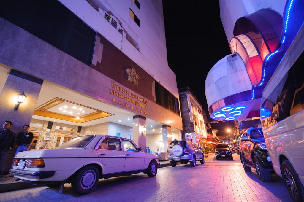 勿洞勿洞梅林酒店的夜间停在城市街道上的白色汽车