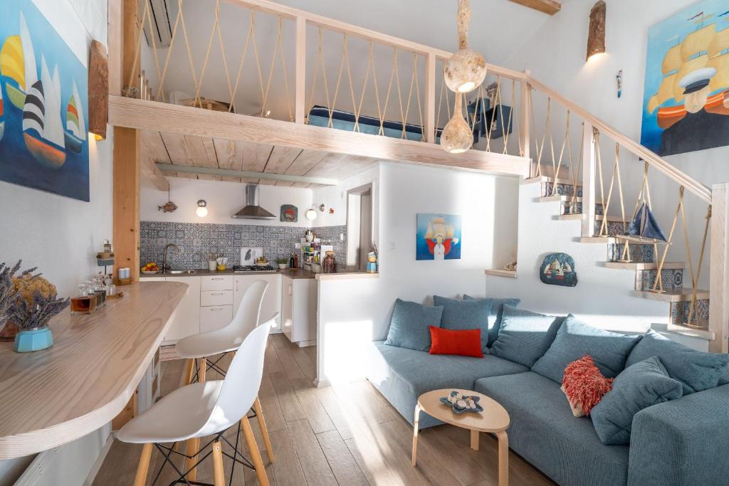 斯塔拉巴斯卡Libera Apartments的一间带蓝色沙发的客厅和一间厨房