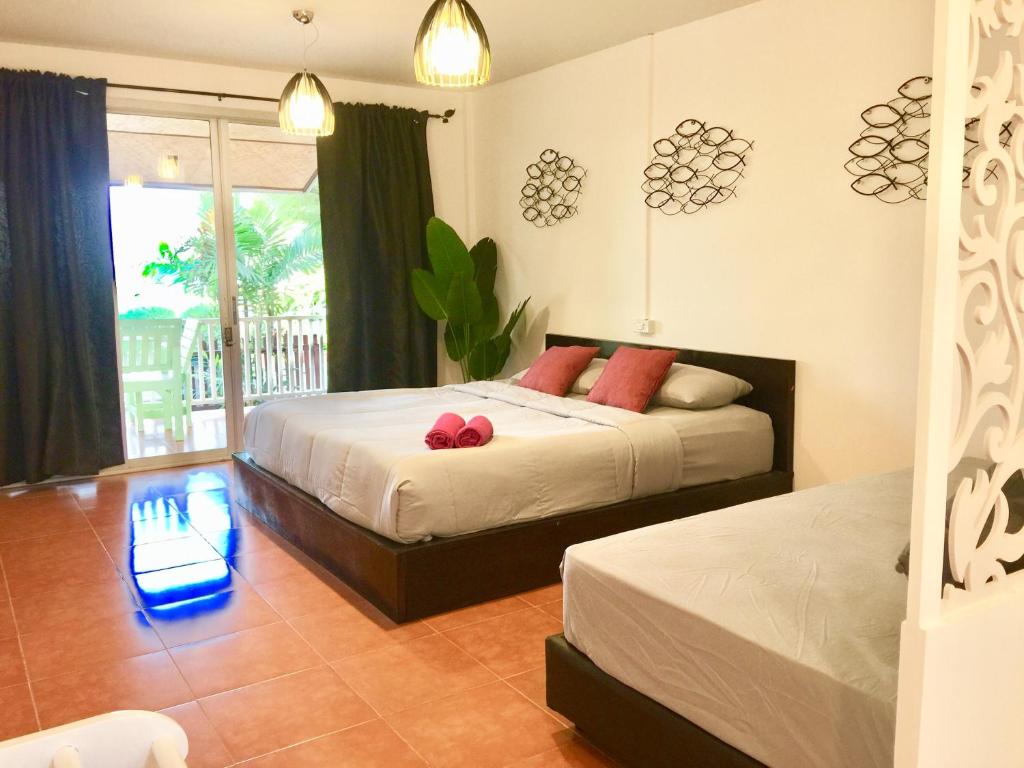 格兰岛Insook Ko Larn Resort的一间卧室设有两张床和窗户。