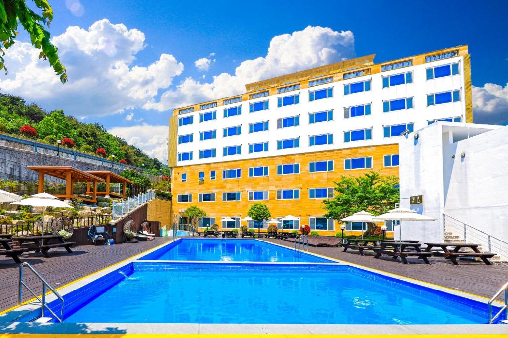 巨济巨济多亚酒店的大楼前设有游泳池的酒店